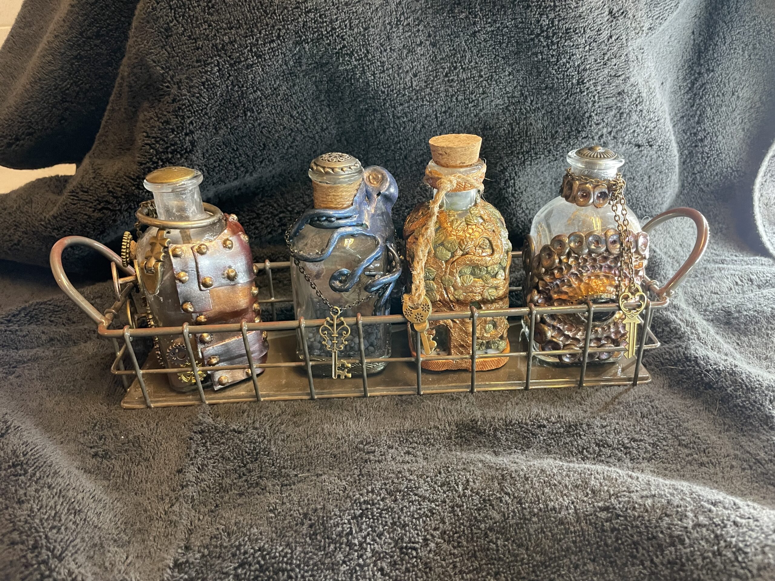 Set of four decorated bottles in a wire basket