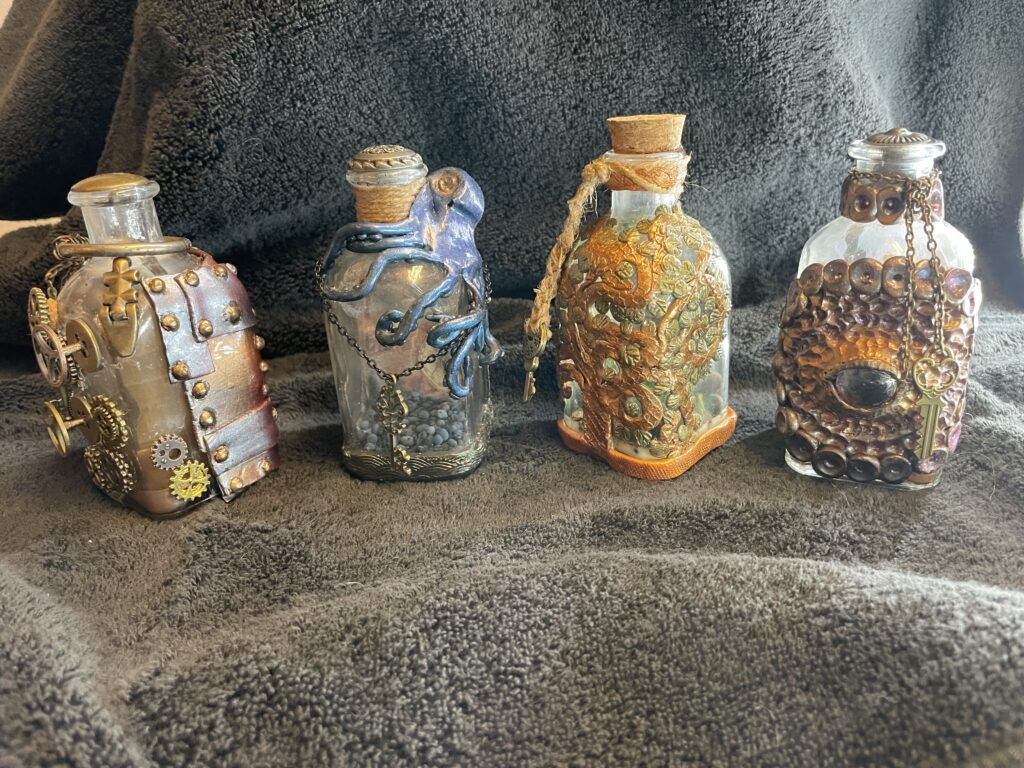 Four small bottles decorated with polymer clay